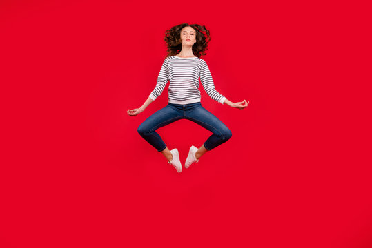 Full length size body photo of fly high pretty charming she her girl getting yoga energy in lotus pose wearing striped white casual sweater on red vivid bright background