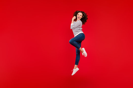 Full length size body photo of fly high attractive beautiful her girl won competitions gladly raised one arm wearing white casual striped sweater on red vivid bright background