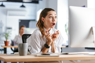 Shocked young businesswoman sitting at her workplace