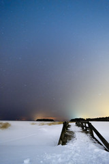 Bridge in winter landscape under starry sky