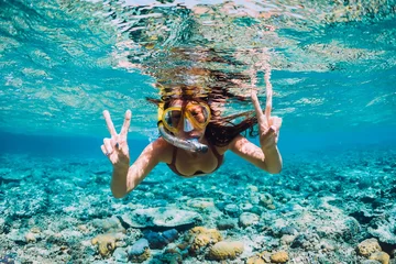 Foto op Aluminium Happy young woman swimming underwater in the tropical ocean © artifirsov