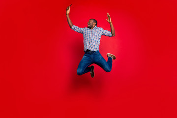 Full length body size of nice funny crazy handsome attractive cheerful cheery positive guy wearing checkered shirt holding in hands cell reading text isolated over bright vivid shine red background