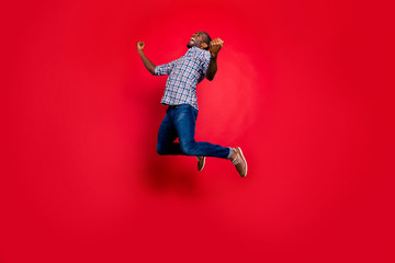 Full length body size portrait of nice funny glad handsome cheerful positive trendy guy wearing checkered shirt showing winning gesture cool party in air isolated on bright vivid shine red background