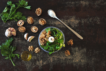 Cooking parsley pesto with walnuts. Ingredients for pesto in a blender cup.