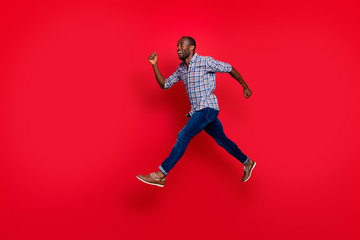 Full length body size profile side view of nice cute handsome attractive cheerful positive sportive guy wearing checkered shirt running in air to goal isolated on bright vivid shine red background