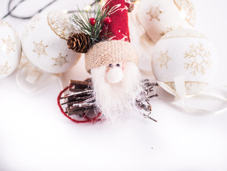 a santa claus decoration with som christmas balls on a white background