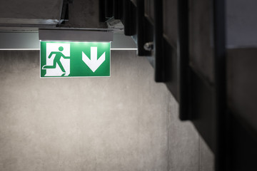 Symbol of escape route in case of danger, Modern concrete building with escape route sign on stairs - 238353800
