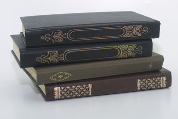 four very old books on a white background close-up