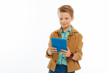 Obraz premium Cheerful positive boy using a new tablet