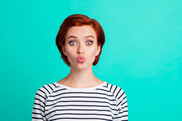 Close-up portrait of nice cute attractive funky amazed red-haired lady in striped pullover sending air kiss isolated over bright vivid shine green turquoise background