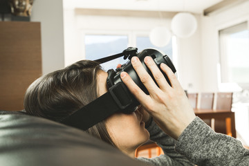 Young woman at home with VR glasses. Virtual Reality Goggles Concept