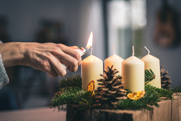 lighting a candle on advent wreath - obrazy, fototapety, plakaty