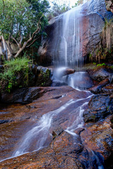Waterfall into stream over flat rocks