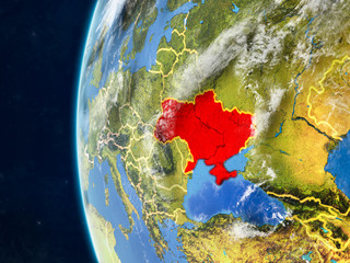 Ukraine from space on model of planet Earth with country borders and very detailed planet surface and clouds.
