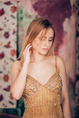 Portrait of sexy glamour blonde woman in Golden dress in Studio