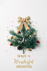 top view of green pine branch decorated as festive christmas tree with bow on white background with...