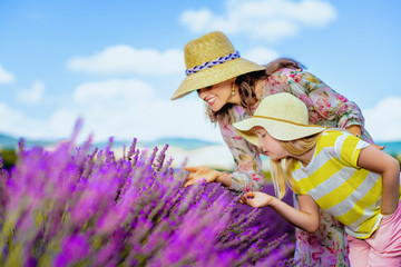 mother and child in lavender field smelling lavender