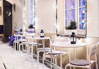 Winter in Europe. City street decorated cafe in a Christmas time. Holidays winter concept