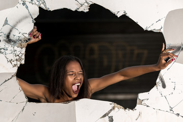Screaming woman breaking wall