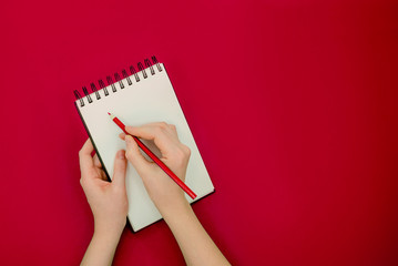 Female hand holding pencil and sketchbook. Mock-up Concept. Bright background, isolated, close up
