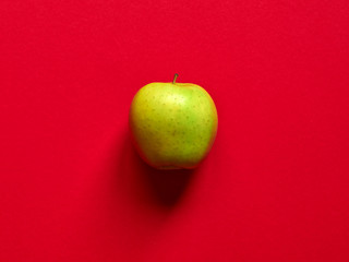 Above view of a Green apple isolated in a red background in studio