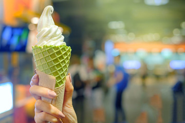 Young woman hands holding soft cream or ice cream cones matcha green tea flavor on light blur...