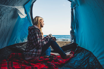 Freedom and alternative tiny house or wild independent vacation concept with blonde girl sitting on...