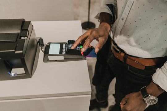 Crop black hand inserting password on payment terminal
