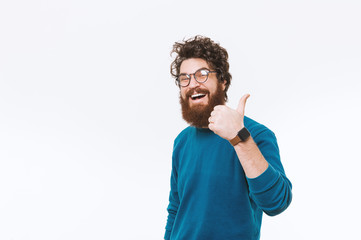 Cheerful smiling bearded hipster man wearing glasses and showing thumbs up