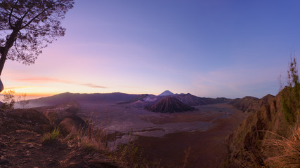 Mount Bromo volcano crater erupts in the caldera, behind Gunung Batok, with Gunung Semeru in the background, Java, Indonesia.