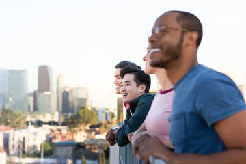 Group of friends looking out at city skyline view on a rooftop