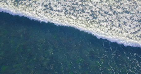 Sea aerial view, top view, amazing nature background. Blue color of the water and beautifull bright. Azure beach with turquoise waves and clear water of ocean on sunny day. Sea view from flying drone