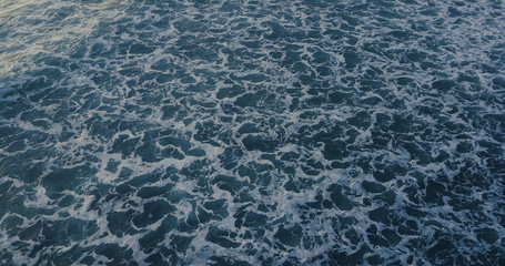 Aerial view beautiful of sea waves from drone. Stock image of blue color of ocean water, sea surface. Top view on turquoise waves, clear water surface texture.  Top view, amazing nature background