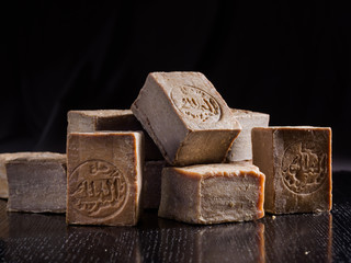 A pile of dried Aleppo soaps, handmade in Syria from traditional methods, with "Al Malak" manufacturer stamp imprinted.