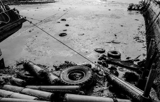 Fototapeta Tube and wheel at sea with low tide time, Black and white