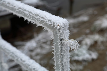 Beautiful white pattern of winter hoarfrost on metal fences