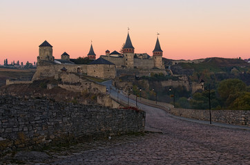 Obraz premium Picturesque view of medieval Kamianets-Podilskyi castle during autumn sunrise. Famous touristic place and romantic travel destination. Kamianets-Podilskyi, Khmelnitsky region, Ukraine