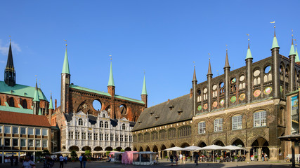 Obraz premium Lübecker Rathaus am Marktplatz – Hanseatic Gothic Backsteinarchitektur mit Marktständen, UNESCO-Weltkulturerbe Lübeck, Schleswig-Holstein