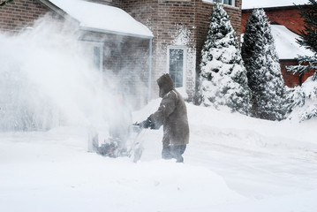Man clearing a drivewy with a snowblower