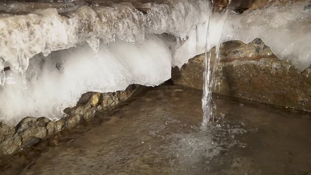 Water is like an endless engine. The source of artesian water flows into the winter frost in a strong winter.