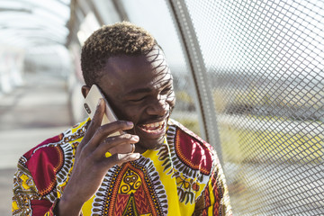 African businessman with smartphone and the clothes of typical