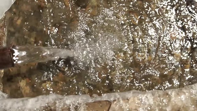 Water is like an endless engine. The source of artesian water flows into the winter frost in a strong winter.