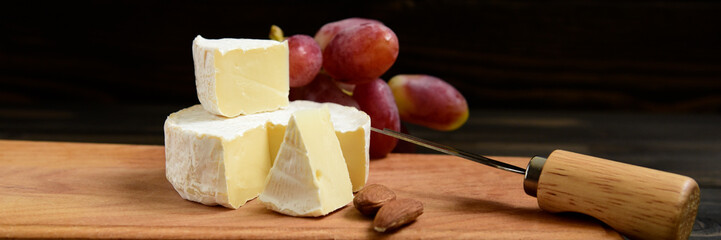 Cheese and grapes on a dark background