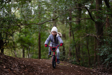 Obraz premium 森の中で自転車に乗る女の子