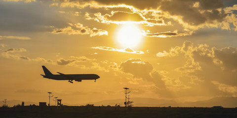 takeoff of the plane on the airfield against the background of the bright sun and beautiful cloudy sky