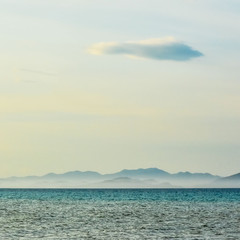 beautiful line of sea and blue sky. majestic mountains in the fog