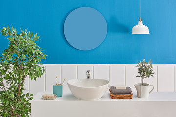 White and blue bath room, sink and mirror decoration on the wall.