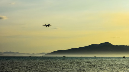 Fototapeta na wymiar small airplane silhouette against a clear yellow sky