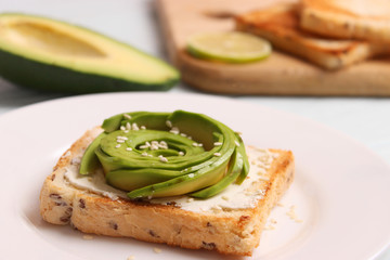 Toasted toast with avocado on a wooden table.