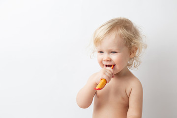 little cute curly baby smiles and cleans teeth on white background